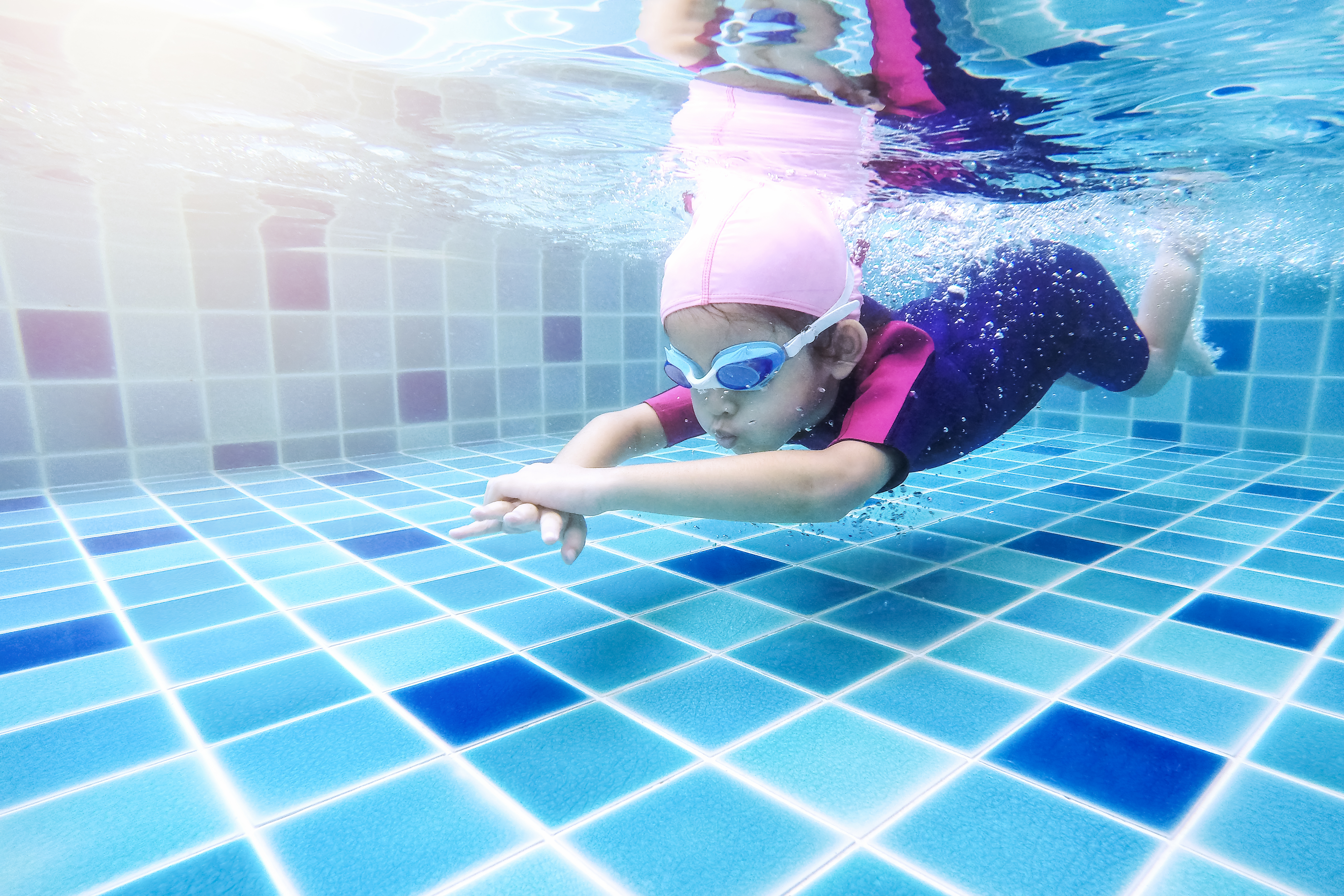 Mała dziewczynka pływa w basenie